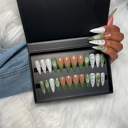 Green & White French Tip Press-On Nails with blooming gel crocodile design, silver studs, and isolated chrome charms. Available in Square, Stiletto, Ballerina, and Coffin shapes