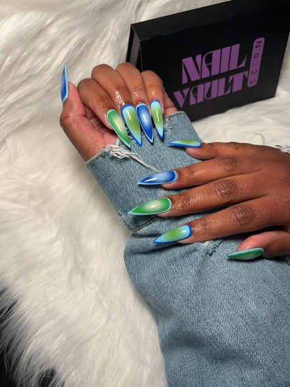 Aura airbrush press-on nails featuring a seamless gradient blend of green, sky blue, and light green tones. Designed for a soft, modern aesthetic with a high-gloss finish. Hand-painted on 100% Gel X tips for a salon-quality, reusable finish. Available in Square, Stiletto, Ballerina, and Coffin shapes