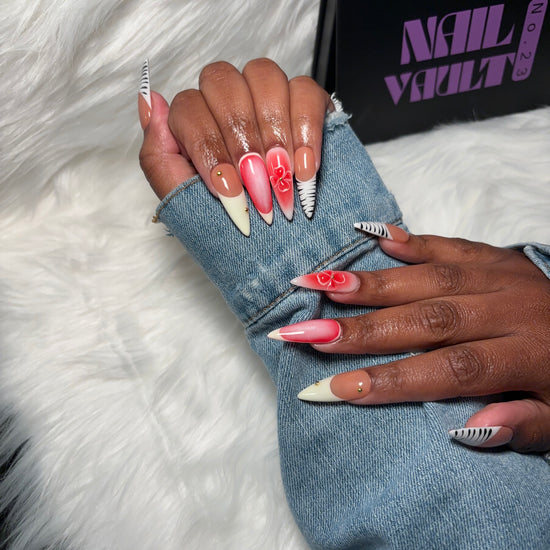 Stylish press-on nails featuring bold zebra French tips, soft pink & white aura airbrush, delicate pink 3D flowers, and elegant gold charm accents. Designed on 100% Gel X tips for a long-lasting, salon-quality, and reusable finish. Available in Square, Stiletto, Ballerina, and Coffin shapes.